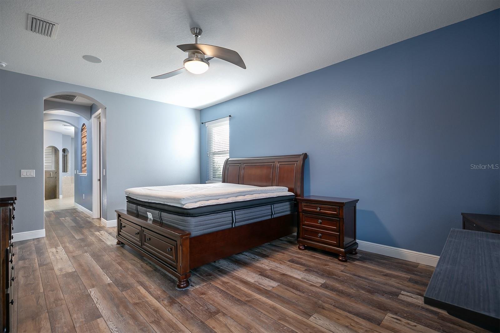 master bedroom with bed and mattress with hallway to bathroom